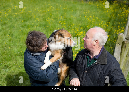 Farmer et femme avec chien de berger Banque D'Images
