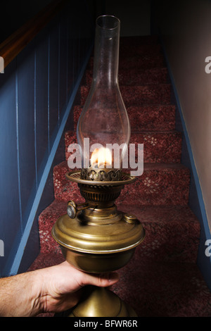 Jusqu'à un escalier sombre avec une vieille lampe à huile. Banque D'Images