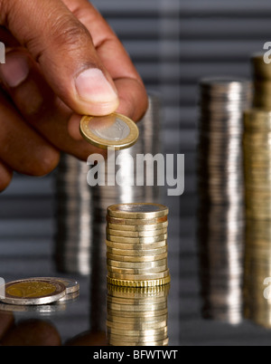 Empilage de pièces en euro de l'homme Banque D'Images