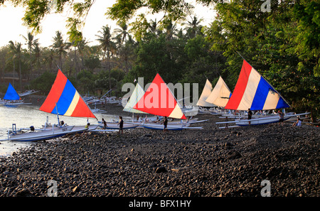 Jukungs, ou des bateaux de pêche balinaise, tiré vers le haut sur la plage, tôt le matin. Tulamben, Bali, Indonésie Banque D'Images