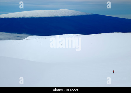 Randonneur solitaire, Mauna Loa volcano vu du volcan Mauna Kea, point le plus élevé à Hawaii, 13796', la grande île d'Hawaï Banque D'Images