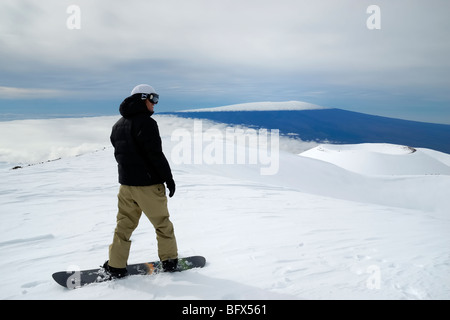 Snowboarder, volcan Mauna Kea, le Mauna Loa volcano dans la distance, point le plus élevé à Hawaii, 13796', la grande île d'Hawaï Banque D'Images