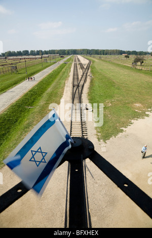 Drapeau israélien et des lignes de chemin de fer menant à l'intérieur de l'entrée de Birkenau (Auschwitz II Birkenau) Camp de la mort nazi. Oswiecim, Pologne. Banque D'Images
