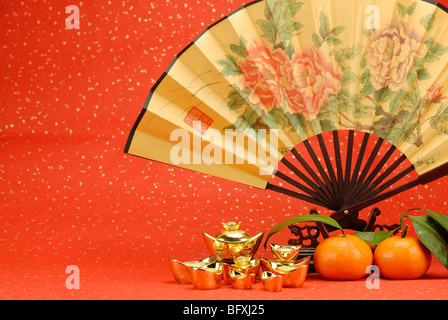 Le nouvel an chinois décoration--traditionnelle avec ventilateur et de lingots d'orange sur fond de fête. Banque D'Images