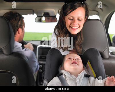 Mère regardant bébé en siège-auto Banque D'Images