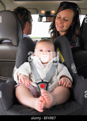 Mère regardant bébé en siège-auto Banque D'Images