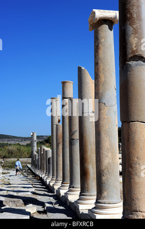 Les touristes à pied par colonnes anciennes qui bordent la voie dans les ruines de Patara Banque D'Images