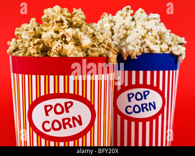 Deux seaux de pop-corn sur fond rouge. Banque D'Images