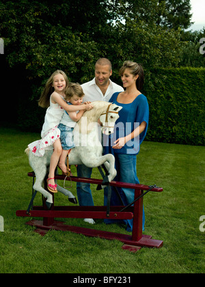 Une famille jouant avec un cheval à bascule Banque D'Images