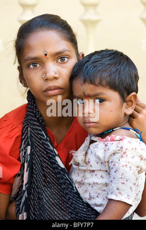 Pauvre fille indienne, berçant sa petite sœur dans une écharpe Banque D'Images