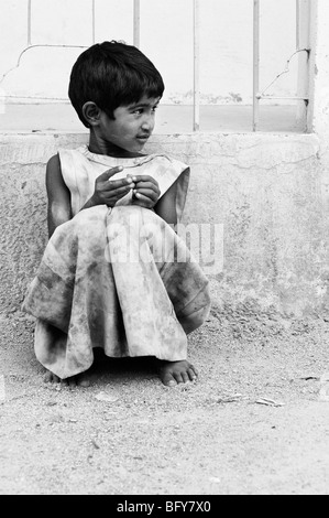 Pauvre Jeune Fille indienne appuyé contre un mur, tout seul dans la rue, dans les régions rurales de l'Inde avec copie espace Banque D'Images