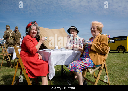 Trois femmes mûres vêtues de costumes d'époque des années 1940 avec thé. Spectacle Aérien De Rafa, Aéroport De Shoreham, Sussex, Angleterre Banque D'Images