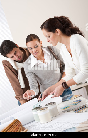 Jeune femme d'intérieur réussie avec deux clients à choisir des couleurs de bureau Banque D'Images