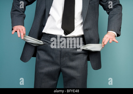 Businessman holding empty pockets Banque D'Images