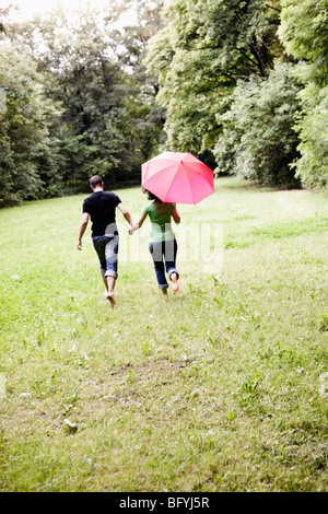 Couple Running Through Grassland Banque D'Images