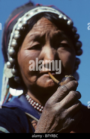 Portrait d'une femme de tribu colline Haini fumant une pipe dans la région de Xishuangbanna de la province de Yunnan, Chine Banque D'Images