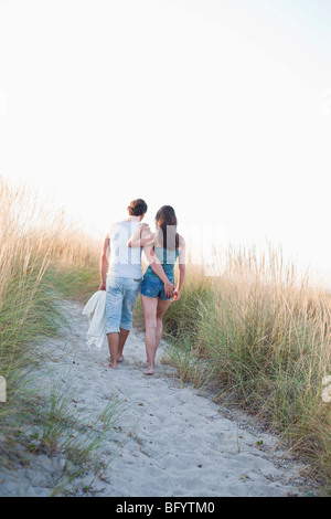 Couple strolling along beach Banque D'Images