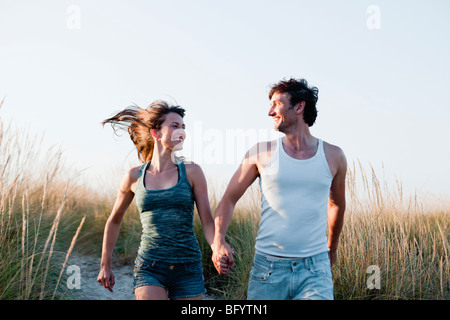 Couple running along beach Banque D'Images