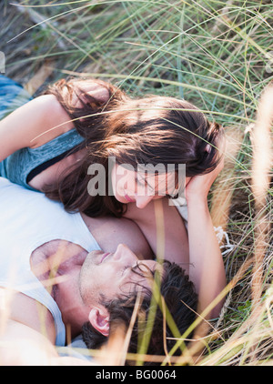Couple lying in grass smiling Banque D'Images