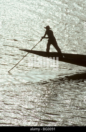 Boatman utilise un poteau pour déplacer son bateau de l'eau peu profonde sur le fleuve Niger, Mali, Afrique de l'Ouest Banque D'Images