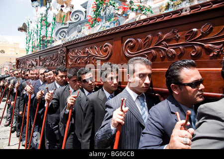 Procession en l'honneur de la Vierge Marie au cours de la Semaine Sainte à Antigua Guatemala. Le flotteur comptable Cucuruchos sur leurs épaules. Banque D'Images