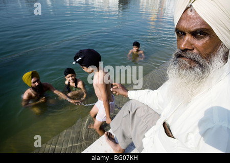 La famille sikh en prenant un bain dans religieux, Temple d'or d'Amritsar, en Inde. Banque D'Images
