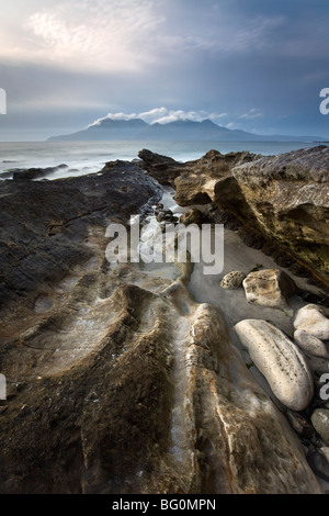 Vue vers l'île de Rum de rochers à Singing Sands (Camas Sgiotaig), à l'île de Eigg, Hébrides intérieures, Ecosse, Royaume-Uni Banque D'Images