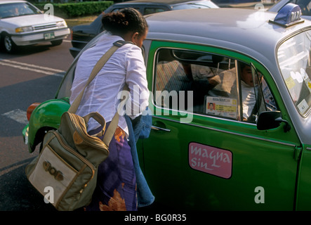 Femme mexicaine d'entrer dans le taxi, femme mexicaine, en taxi, bug VW vert, quartier Zona Rosa, Mexico, District Fédéral, Mexique Banque D'Images