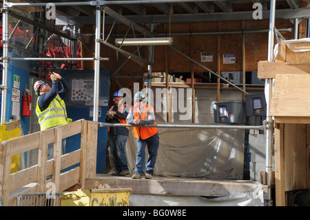 Les travailleurs de la construction du World Trade Center à Manhattan. Sur une pause déjeuner, l'un d'eux sort sa caméra. Banque D'Images