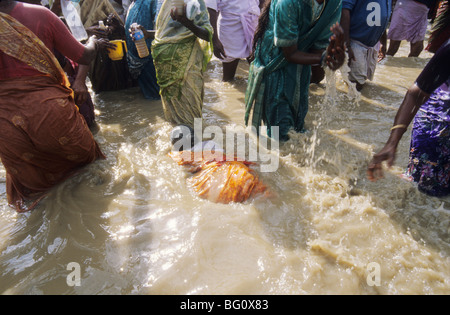 Les pèlerins et les dévots prendre une immersion sainte et splash sur l'un l'autre dans le temple Mahamaham réservoir pendant l'Hindu Kumb Mela festival qui est célébré tous les 12 ans dans un petit temple-ville de Kumbakonam dans l'Etat du Tamil Nadu, en Inde. On croit que l'adoption d'une baignoire ou d'aspersion d'eau le réservoir sur leurs corps ne les purifier de tous leurs péchés. Ce festival, appelé le festival Mahamaham, a eu lieu en mars 2004. Banque D'Images