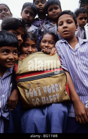 Les enfants de l'école avec un sac à dos dont worry be happy à Madurai, Inde Banque D'Images