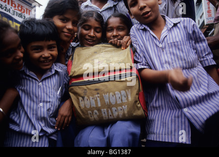 Les enfants de l'école avec un sac à dos ne worry be happy à Madurai, Inde Banque D'Images