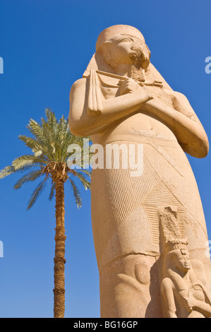 Statue du pharaon Ramsès II avec fille bent'anta entre ses jambes derrière le premier pylône du Temple de Karnak, Thèbes, Egypte Banque D'Images