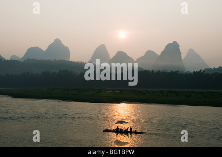 Bateau de tourisme navigation à travers le paysage karstique au lever du soleil sur la rivière Li (Lijiang) dans la région de Yangshuo, nr Guilin, province du Guangxi, Chine Banque D'Images