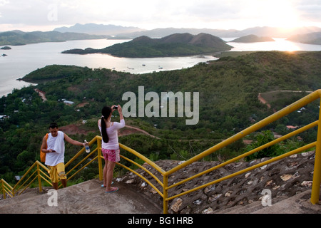 Les touristes prennent des photos de coucher de soleil depuis le mont Tapyas à Coron Town dans la province de Palawan, aux Philippines. Banque D'Images