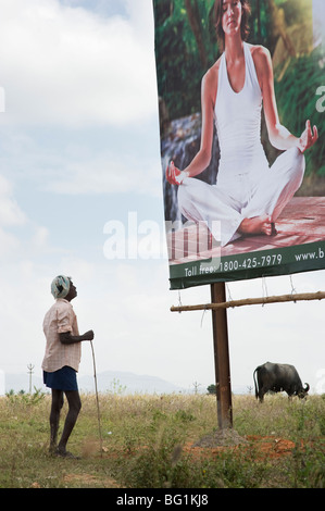 Ancien agriculteur indien à la recherche d'un style à l'ouest la méditation de yoga dans la campagne indienne de Billboard. L'Andhra Pradesh, Inde Banque D'Images