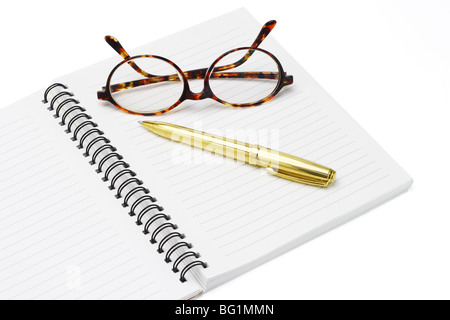 Stylo et lunettes sur un ordinateur portable sur fond blanc Banque D'Images