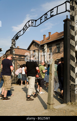 Les touristes à l'entrée principale - avec du vrai Arbeit macht frei slogan au-dessus de la porte - à Auschwitz camp nazi à Oswiecim, Pologne Banque D'Images