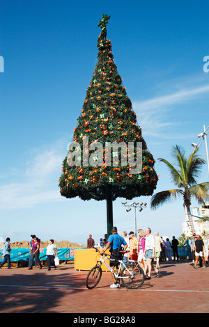 Policier à vélo près d'un arbre de Noël en plein air plage propose dans le secteur de l'agriculture à Banque D'Images