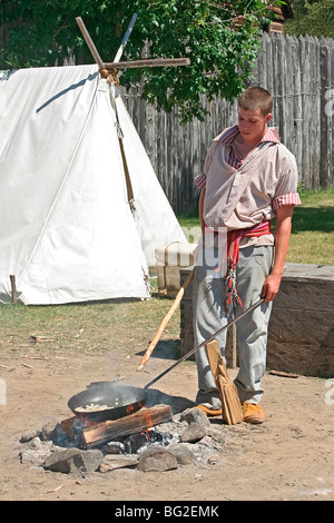 Voyageur (pioneer working man) cuisiniers jusqu'repas typique du maïs frit dans la graisse d'ours au parc historique du Fort William, Thunder Bay Banque D'Images