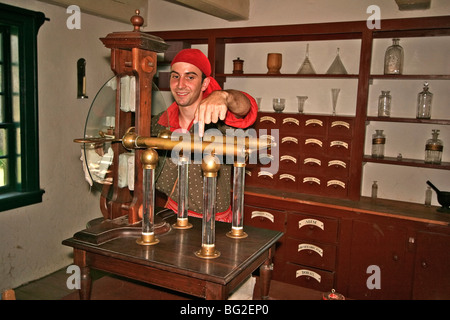 Voyageur (Pioneer) homme de travail à Fort William Historical Park démontre machine électrique utilisé par les médecins au début des années 1800 Banque D'Images