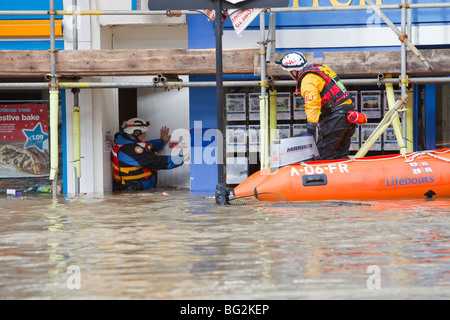 Les sauveteurs RNLI et évacuer les résidents de la rue main Cockermouths lors des inondations de novembre 2009. Banque D'Images