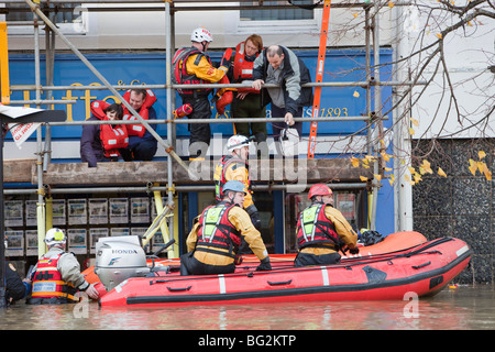 Les sauveteurs RNLI et évacuer les résidents de la rue main Cockermouths lors des inondations de novembre 2009. Banque D'Images