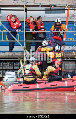 Les sauveteurs RNLI et évacuer les résidents de la rue main Cockermouths lors des inondations de novembre 2009. Banque D'Images