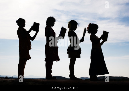 Silhouette d'Indian girls reading books debout dans une ligne Banque D'Images