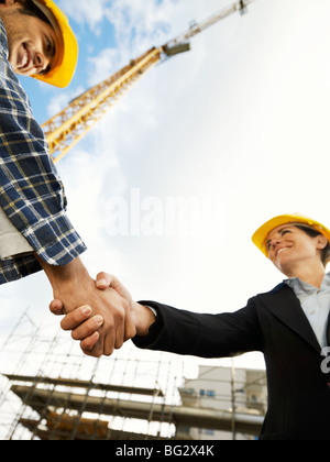 Architecte femelle et construction worker shaking hands. Low angle view, copy space Banque D'Images
