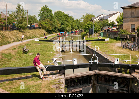 Un homme âgé assis et d'observer la Kennet and Avon Canal à Devizes Wiltshire England UK Une scène vue à partir de la voie publique Banque D'Images