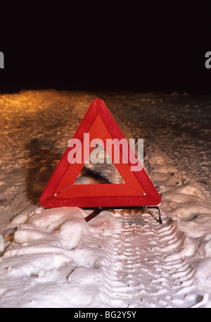 Triangle de présignalisation sur route de campagne hiver neige profonde dans la nuit près de Leeds Yorkshire UK Banque D'Images