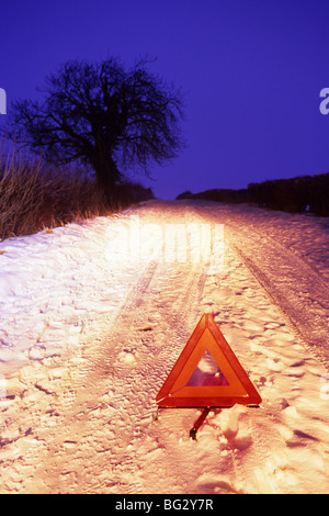 Triangle de présignalisation sur route de campagne hiver neige profonde au crépuscule près de Leeds Yorkshire UK Banque D'Images