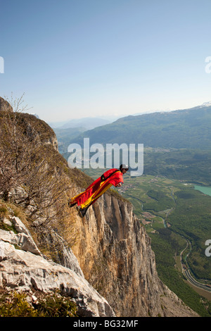 BASE jump à partir d'une falaise. L'ultime coup franc pour faire un objet avec un saut de wingsuit et voler tout près le long de la montagne. Banque D'Images